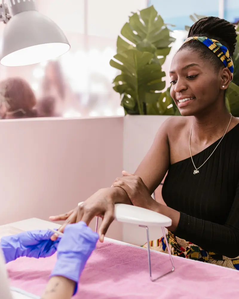 African woman having a manicure at a modern nail salon