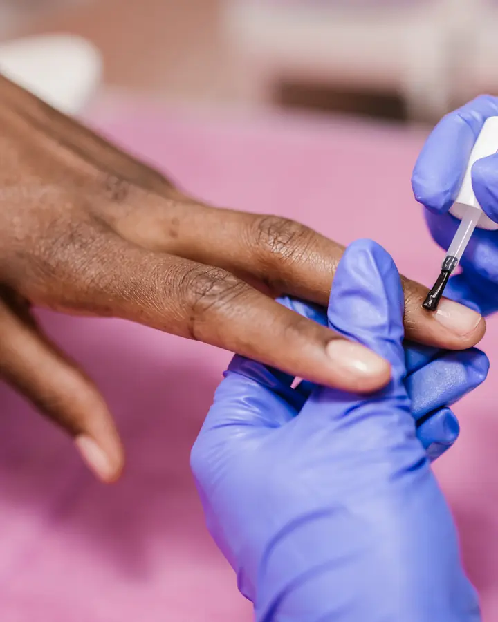 Short nails being polished in a salon