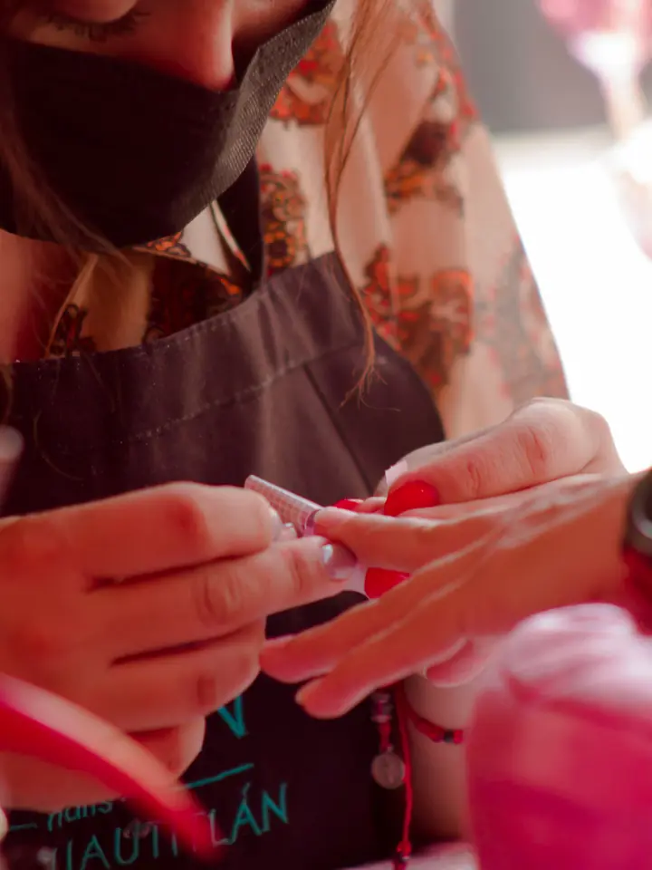 Nail technician building acrylic extensions in a salon